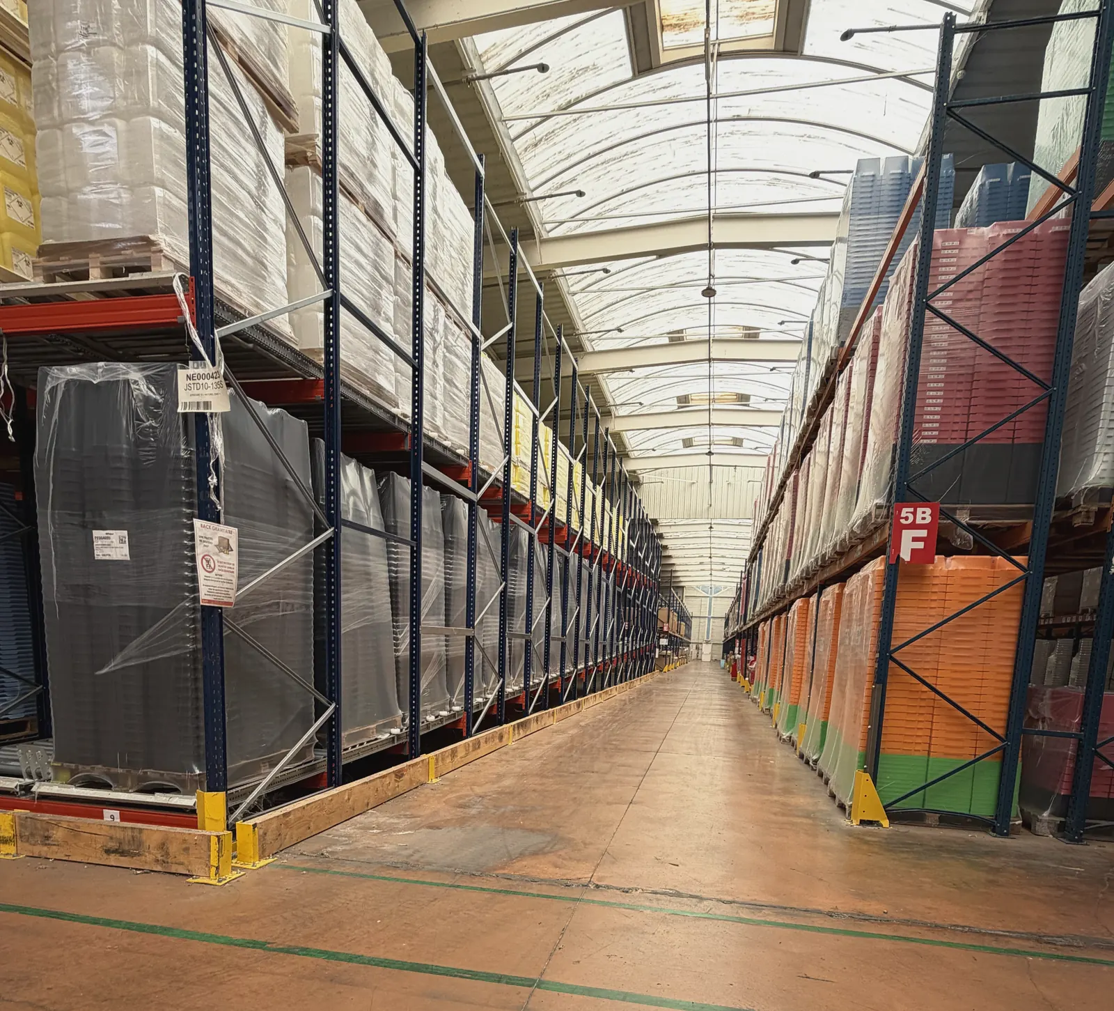 Allée de racks de stockage dans l'entrepôt de Plazur Industries.