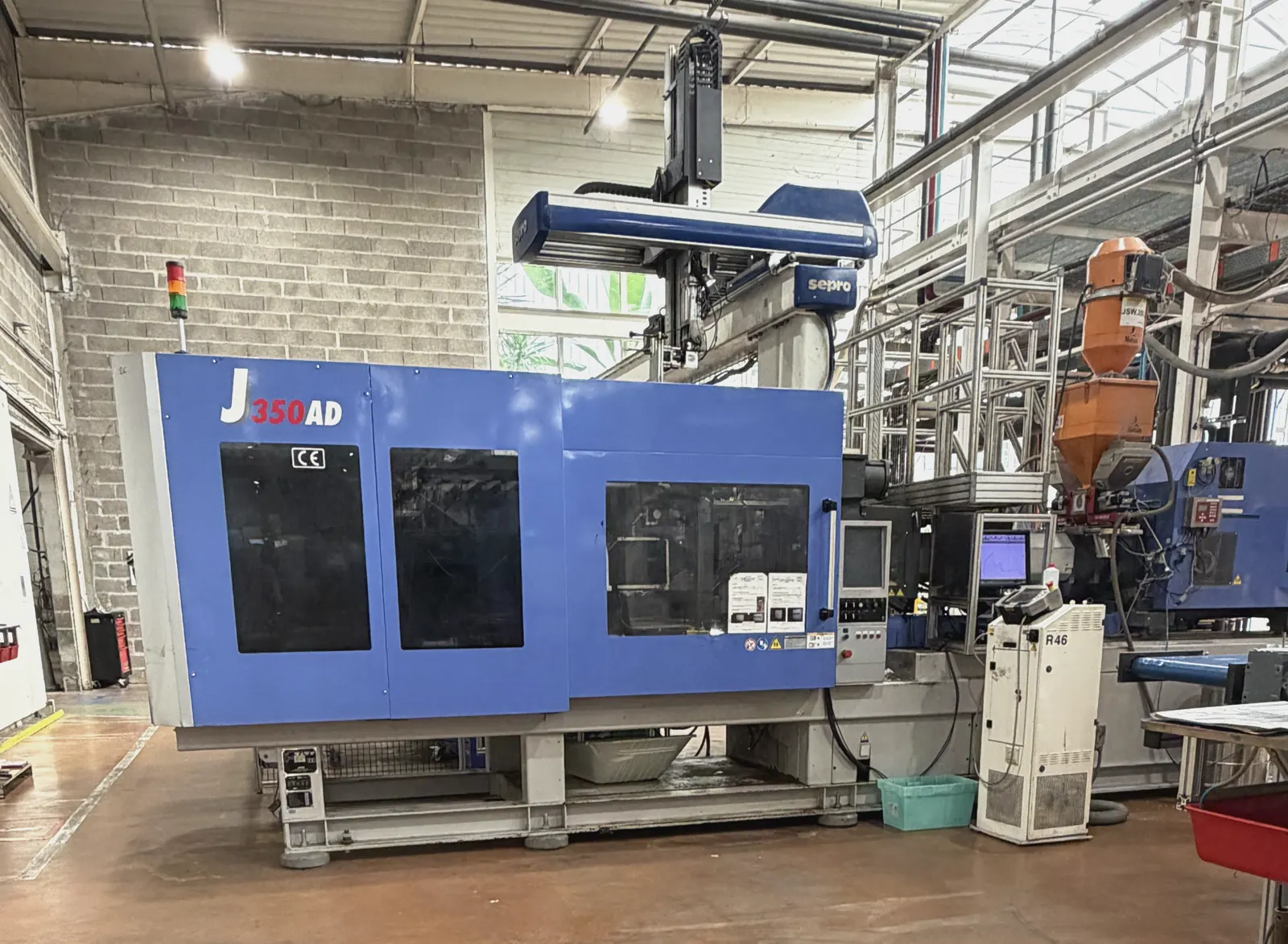 Presse à injecter équipée d'un portique de préhension, atelier Plazur Industries.